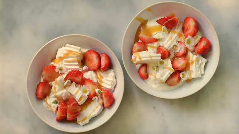 Eton mess med jordgubbar, kolasås, maräng och blommor